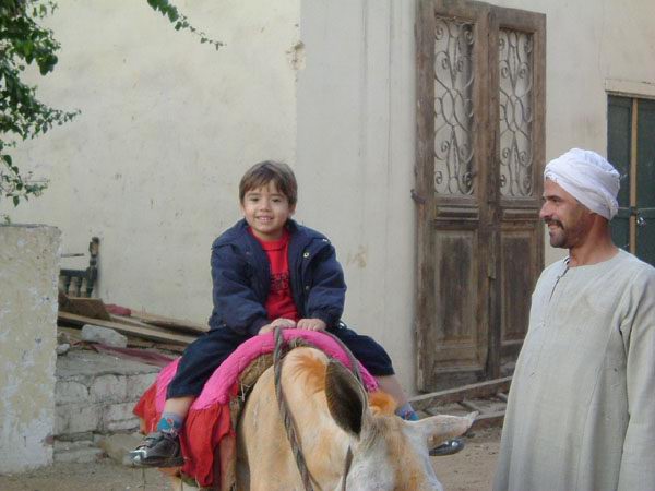 My son Murad, riding a donkey, at Andrea restaurant